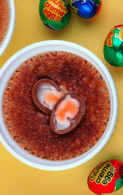 Overhead shot of Cadbury Crème Egg Creme Brulee with exposed creme egg in middle of dessert.
