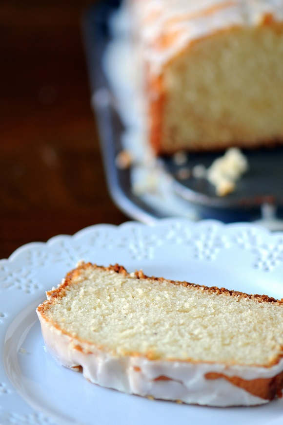 Shot of Cinnamon Sugar Eggnog Cake slice on a plate with remaining cake in the background.
