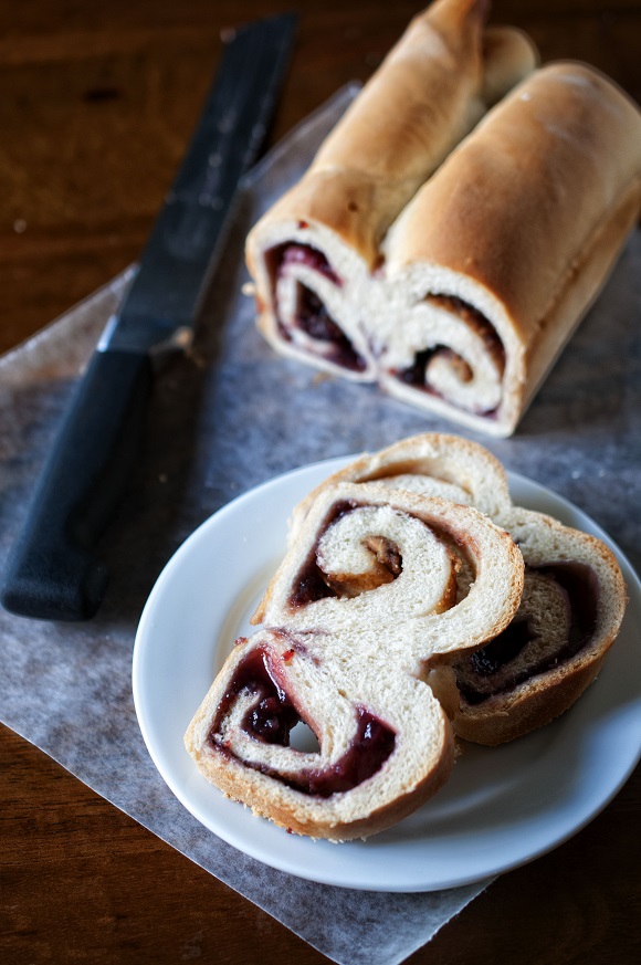 Photo of PB and J bread with slices on a plate. 