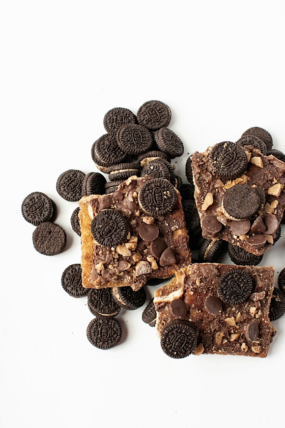 Overhead shot of three pieces of cracker toffee with extra Oreos scattered around