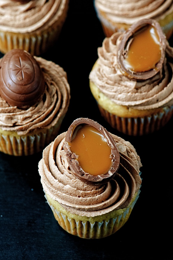 Five banana cupcakes with the caramel eggs dripping down the cupcake.