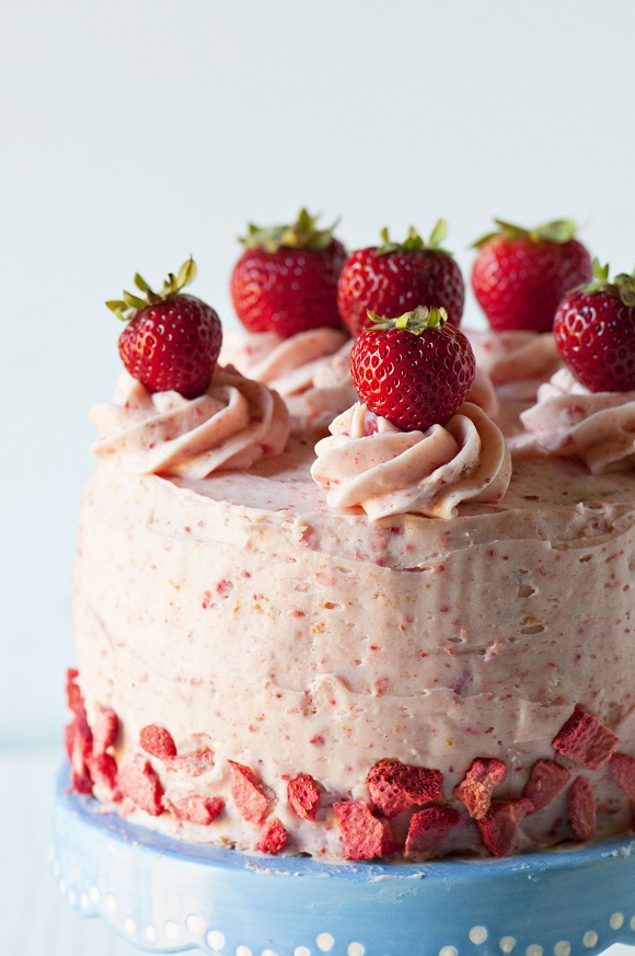 Side view of Strawberry Shortcake Layer Cake with close up of the strawberries on top of the cake.