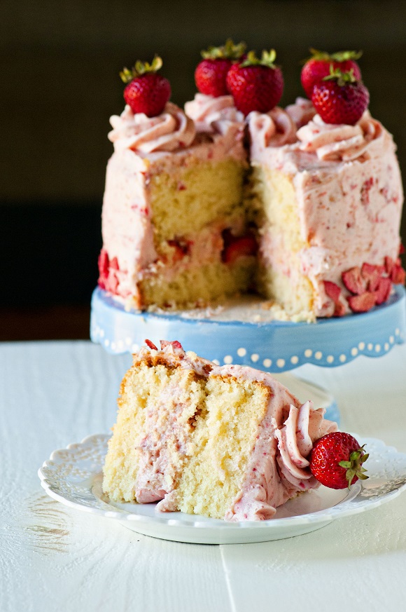 Slice of Strawberry Shortcake Layer Cake with cake in the background.