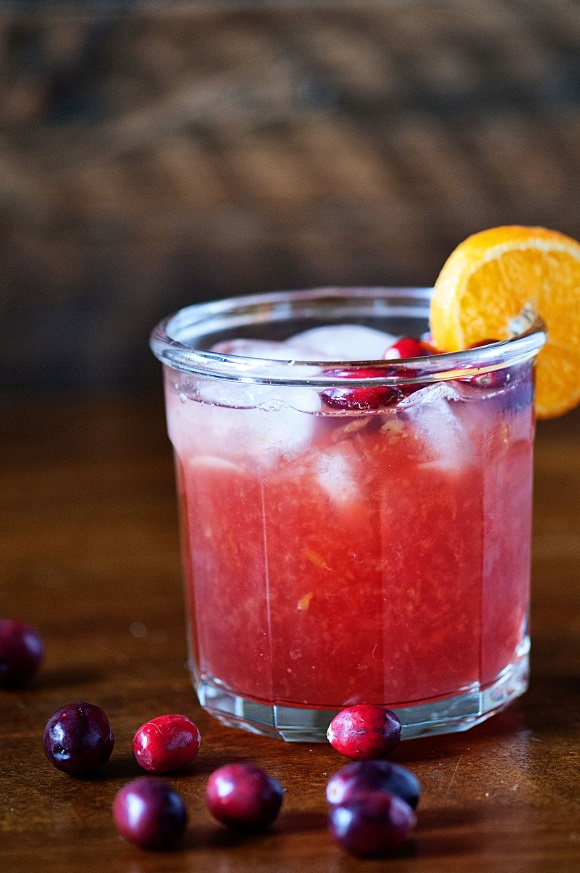 Screw'dged Cocktail with cranberries around it