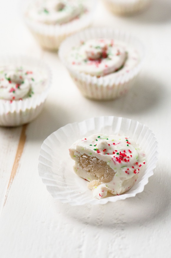 Sugar Cookie Dough Truffle Cups with one cut open showing the filling inside. 