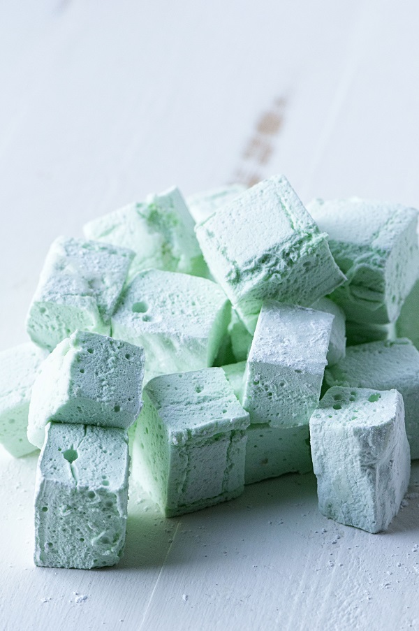 Side view of pile of green marshmallows. 
