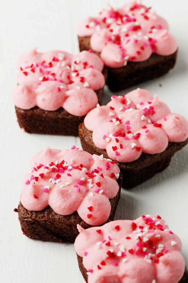 Cinnamon Brownies with Red Hot Infused Buttercream Frosting in a row covered with heart sprinkles