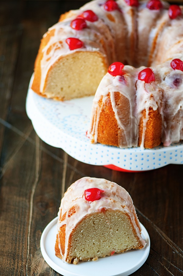 Slice of Vanilla Coke Float Pound Cake on a white plate with remaining cake on a cake stand