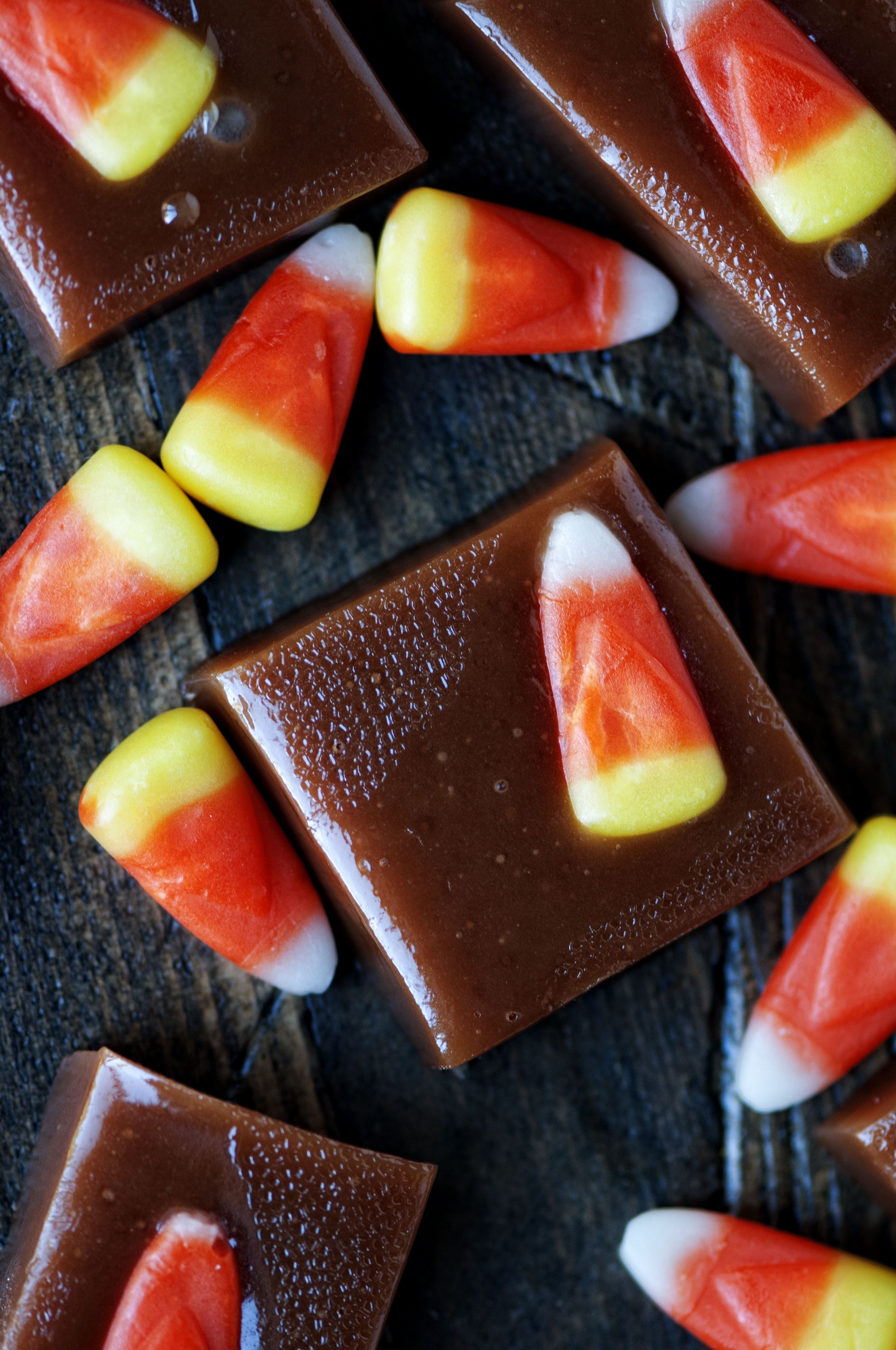 Close up shot of candy corn caramels scattered around with extra candy corns