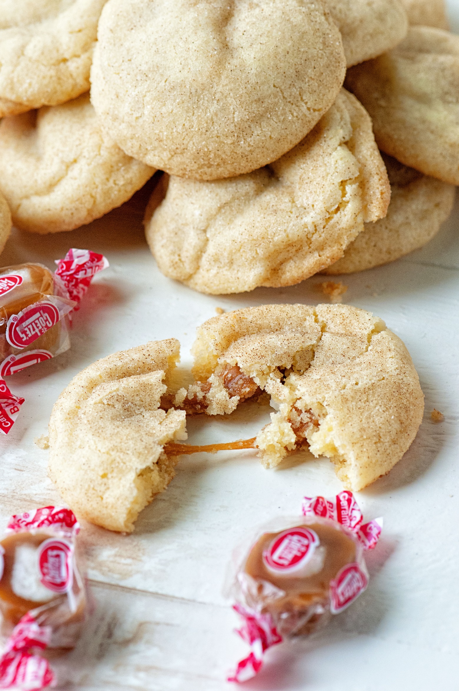 Snickerdoodle cookie torn apart with caramel being pulled.