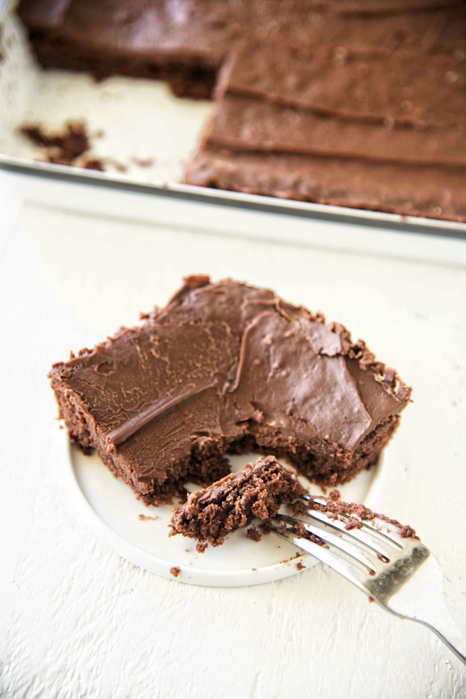 Slice of Jack and Coke Texas Sheet Cake with fork cutting into it.