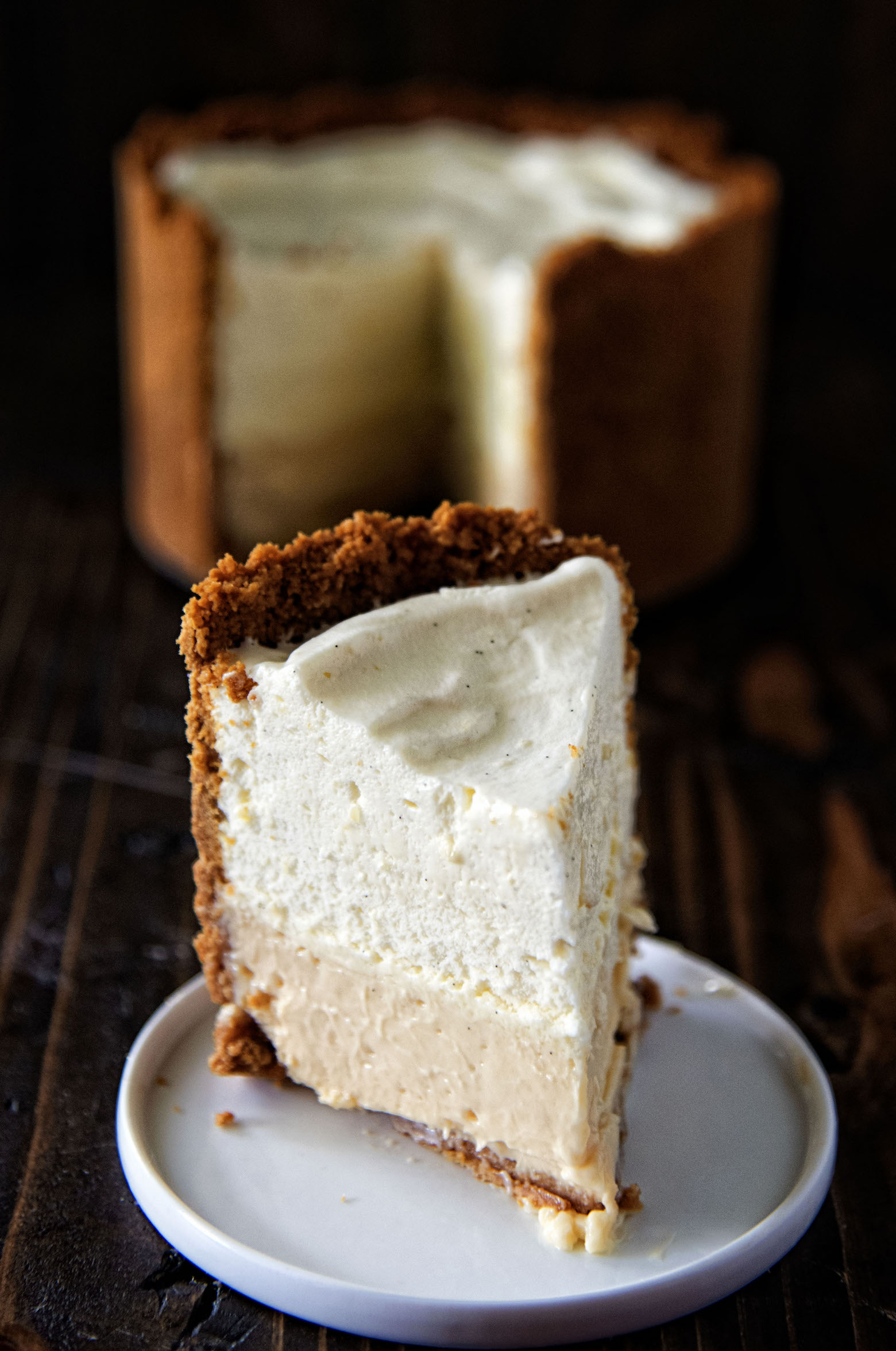 Slice of Mile High Key Lime Pie facing forward with full pie in background.