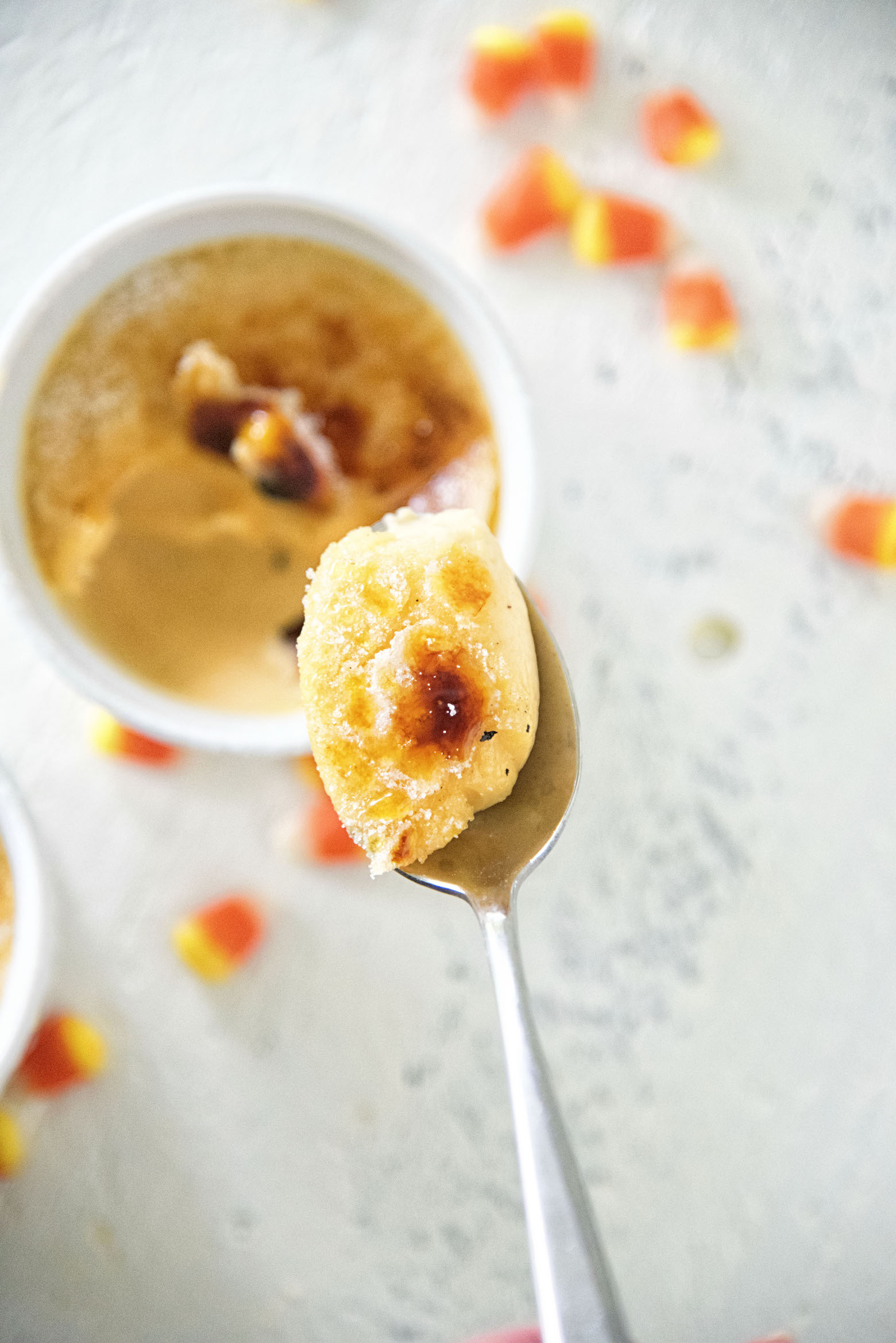 Candy Corn Creme Brûlée with spoon coming up towards the camera