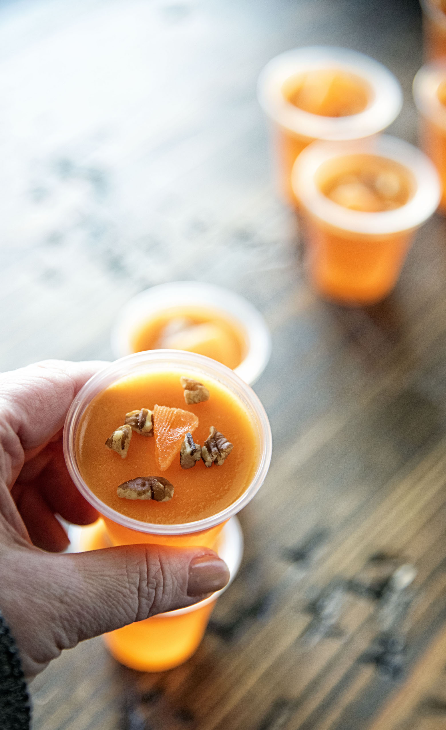 Orange Maple Pecan Bourbon Jell-O Shots held in had for up close shot.