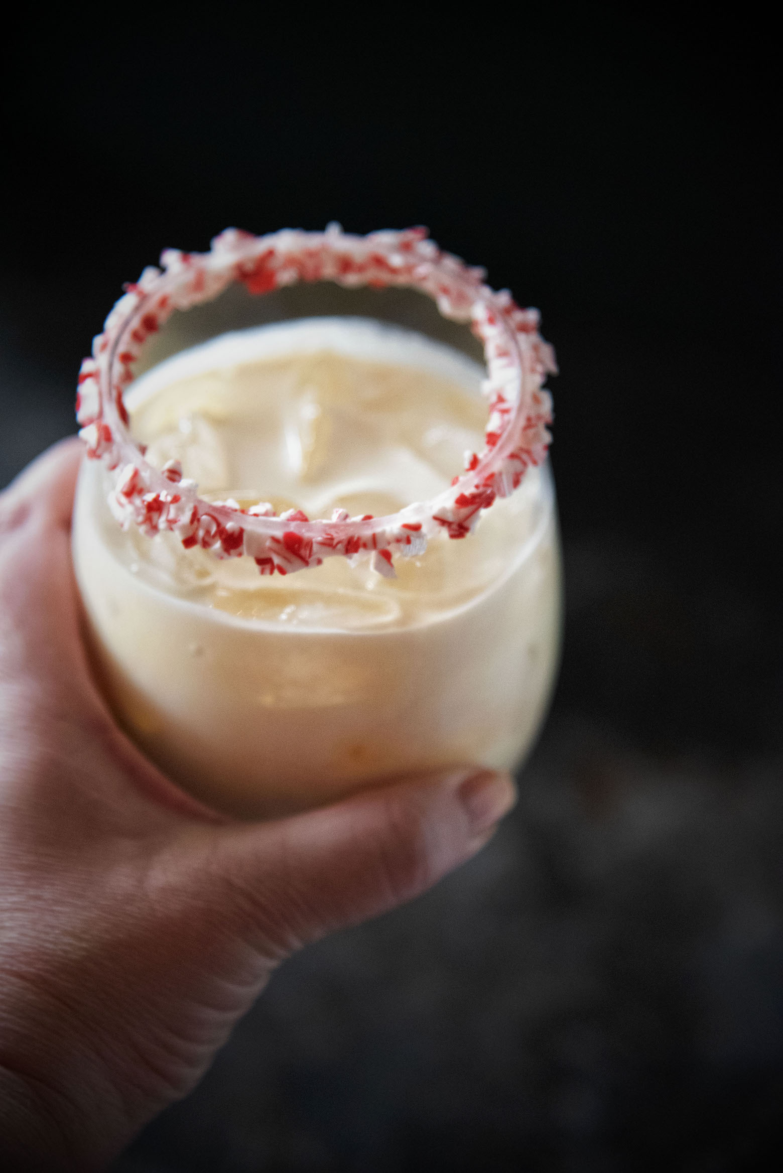 A person holding a Peppermint White Russian in their hand.