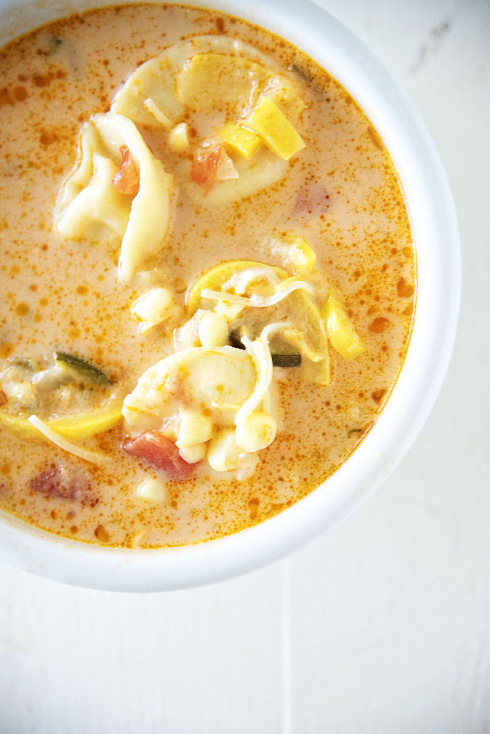 Cheese Tortellini Zucchini Corn Soup in a bowl upclose.