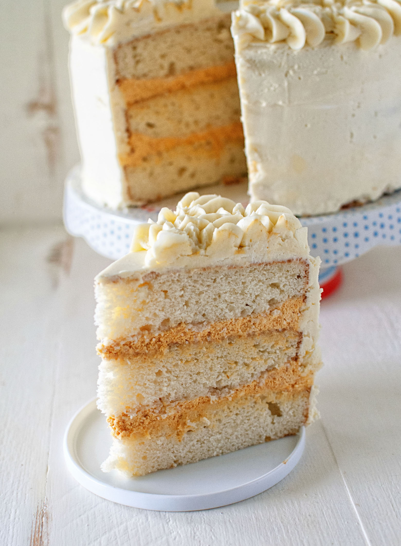 Slice of Buttermilk Bourbon Pumpkin Cheesecake Layer Cake on small plate.