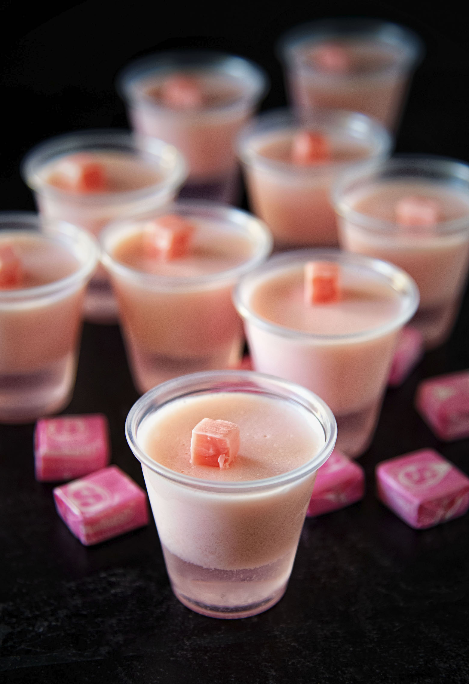 A bunch of Pink Starburst Jello Shots surrounded by pink Starburst candies.