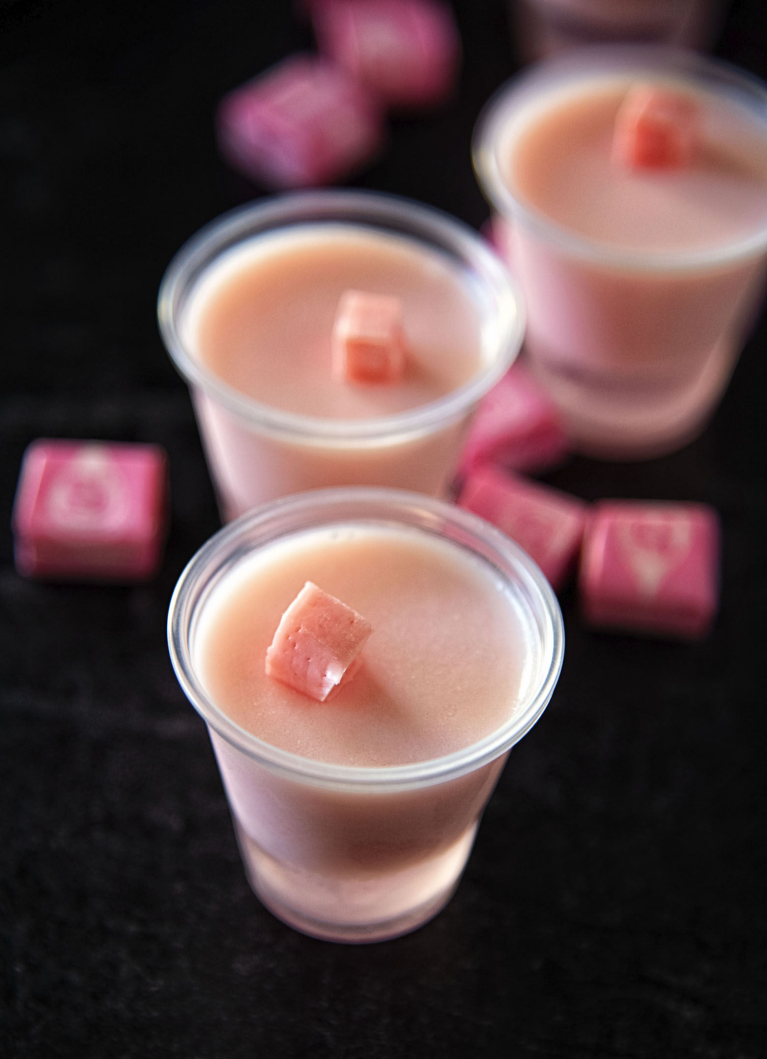 Three Pink Starburst Jell-O Shots with first shot having the close up.