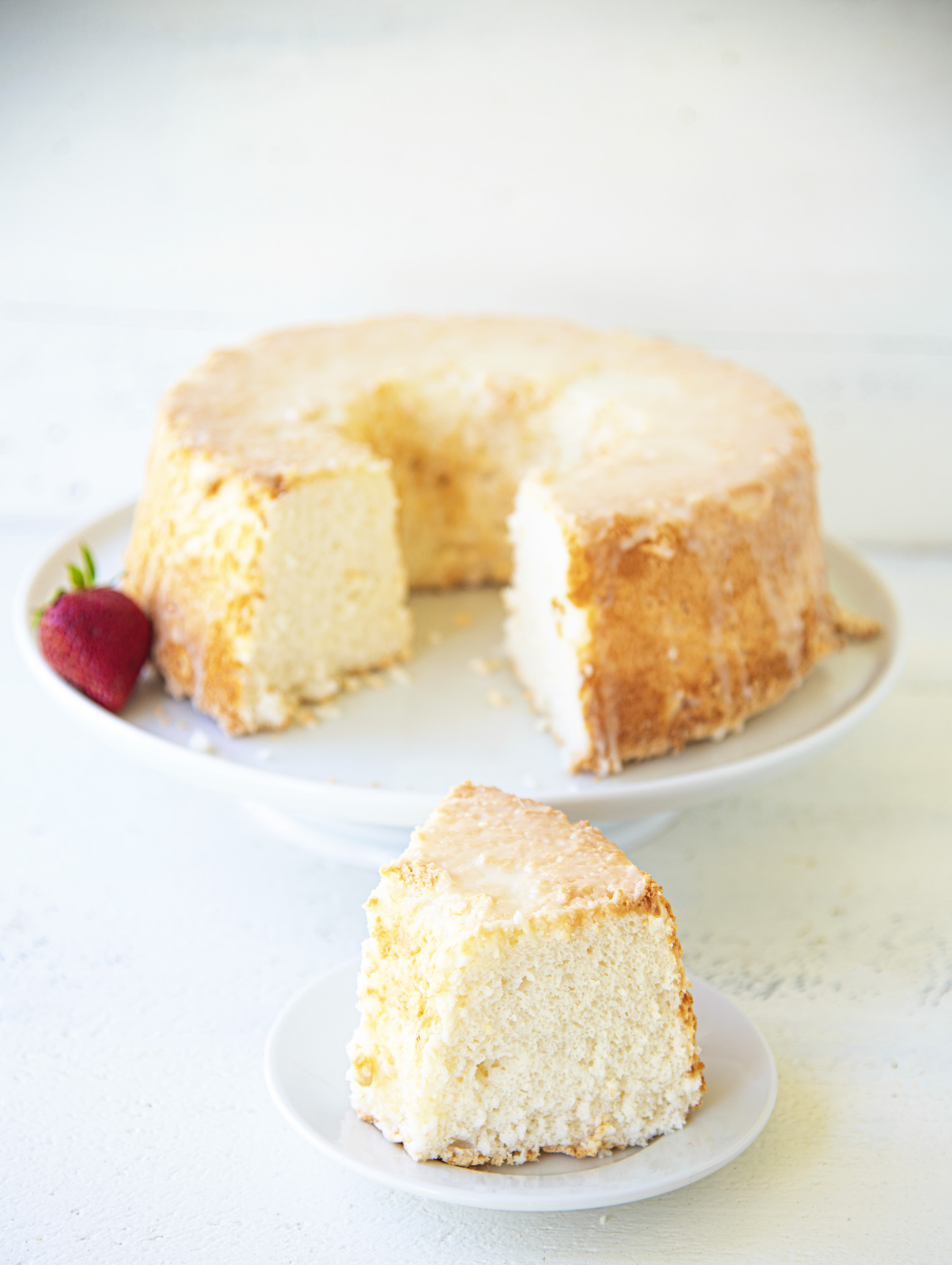 Key Lime Angel Food Cake with slice out of it on a plate. 