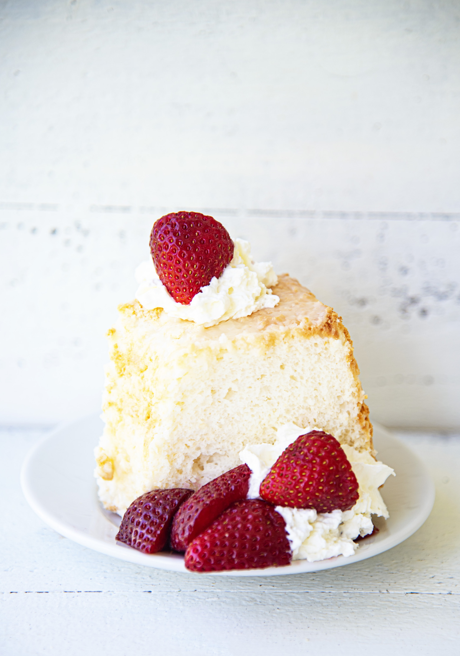 Slice of Key Lime Angel Food Cake with whipped cream and strawberries