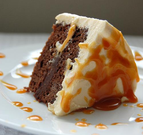 A slice of Bailey's Caramel Irish Cream Cake on a plate with caramel drips everywhere. 