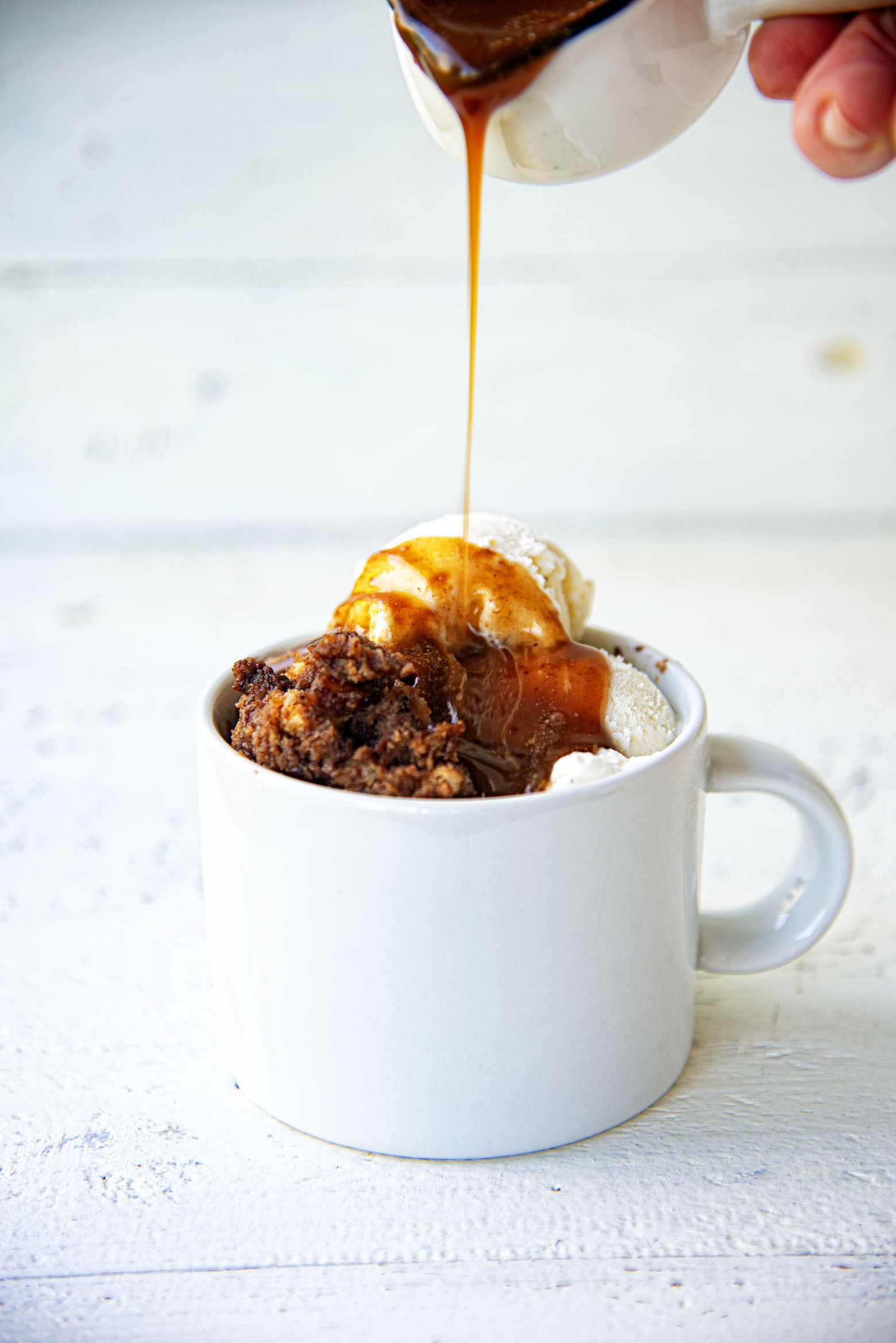 Coffee and Donuts Bread Pudding with sauce being drizzled on it. 