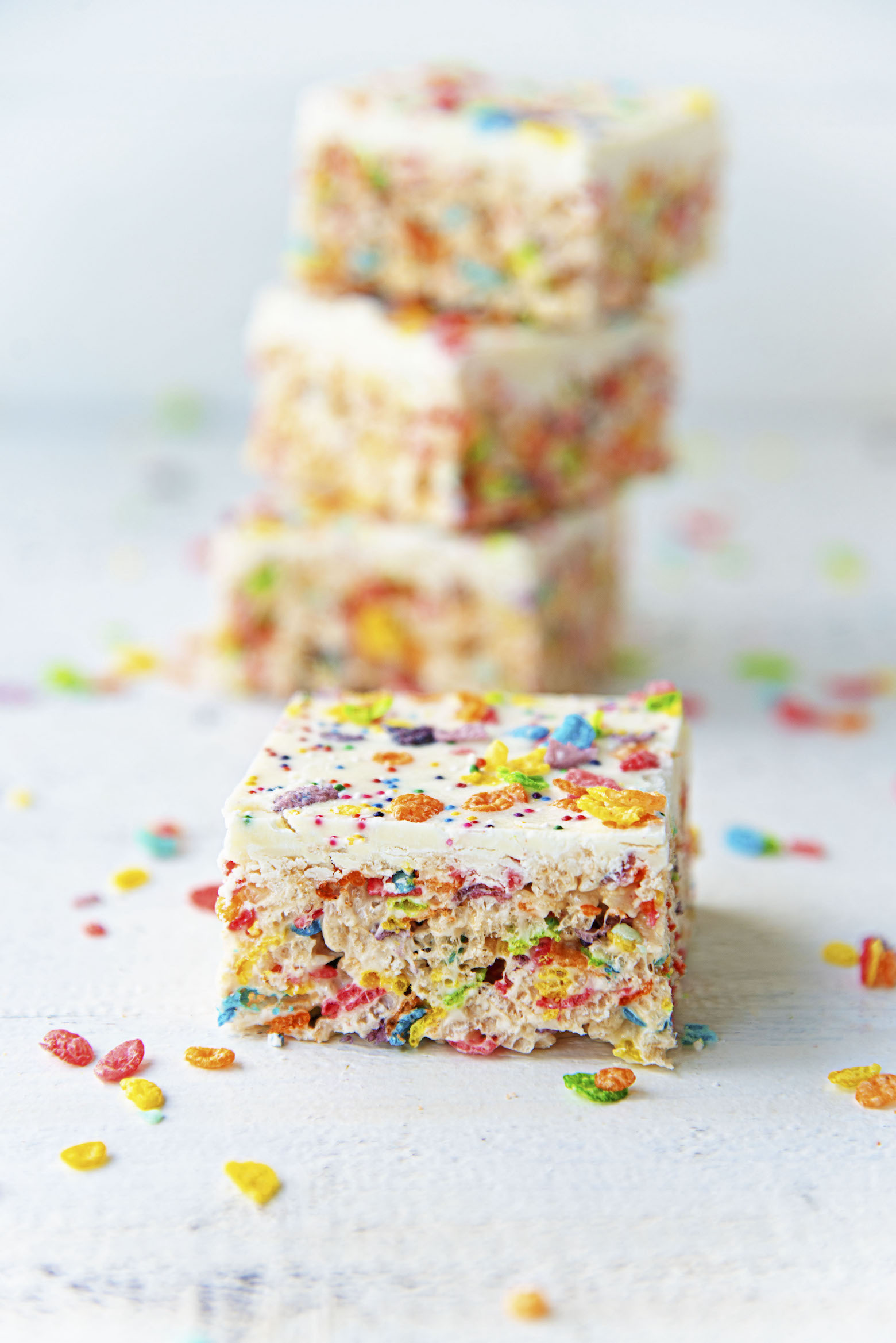 White Chocolate Fruity Pebbles Marshmallow Treats stacked up.