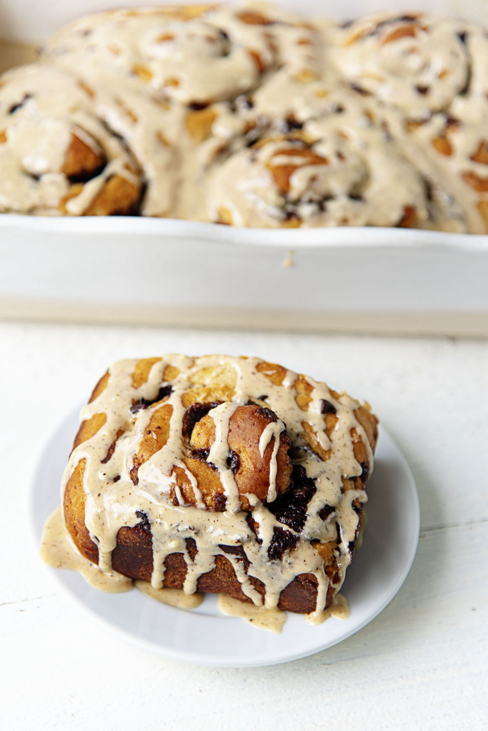 Three quarter view of Banana Espresso Chocolate Sweet Rolls in both pan and on plate.