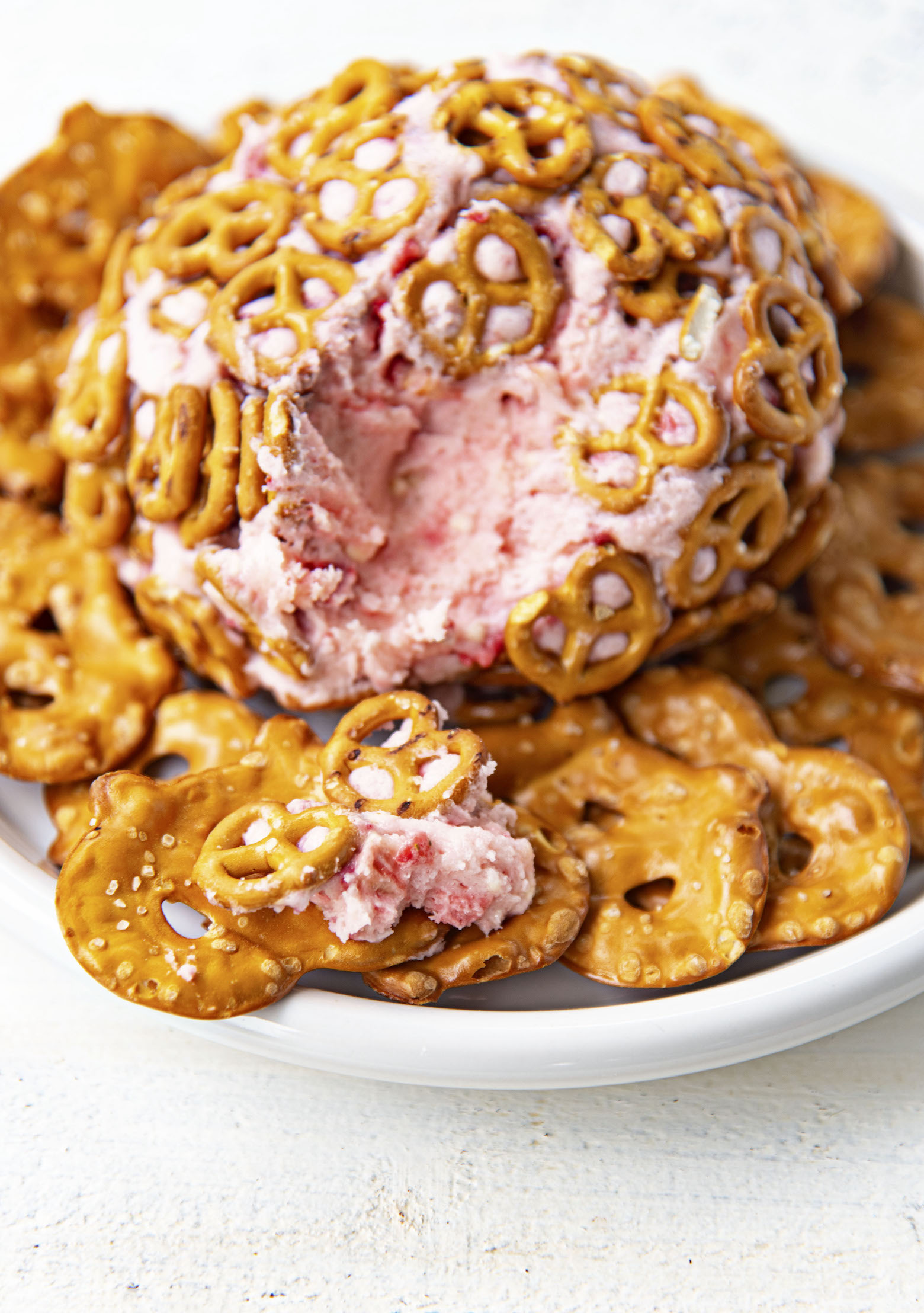 Close up of pretzel chip with Strawberry Pretzel Cheesecake Cheese Ball on it.