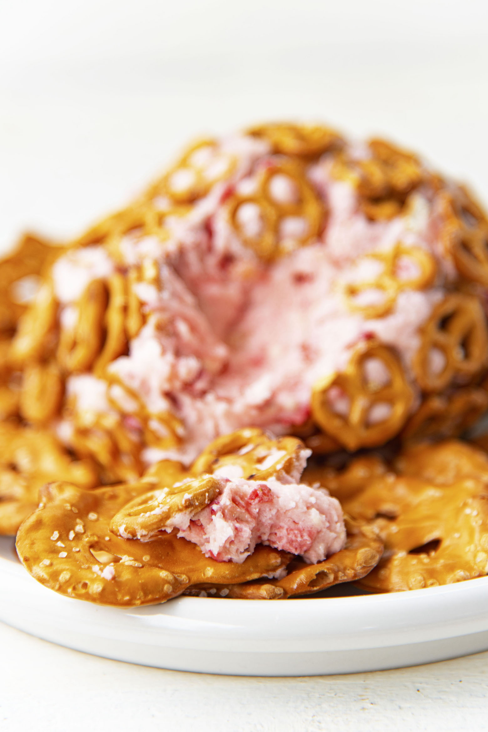 Close up of pretzel chip with Strawberry Pretzel Cheesecake Cheese Ball on it