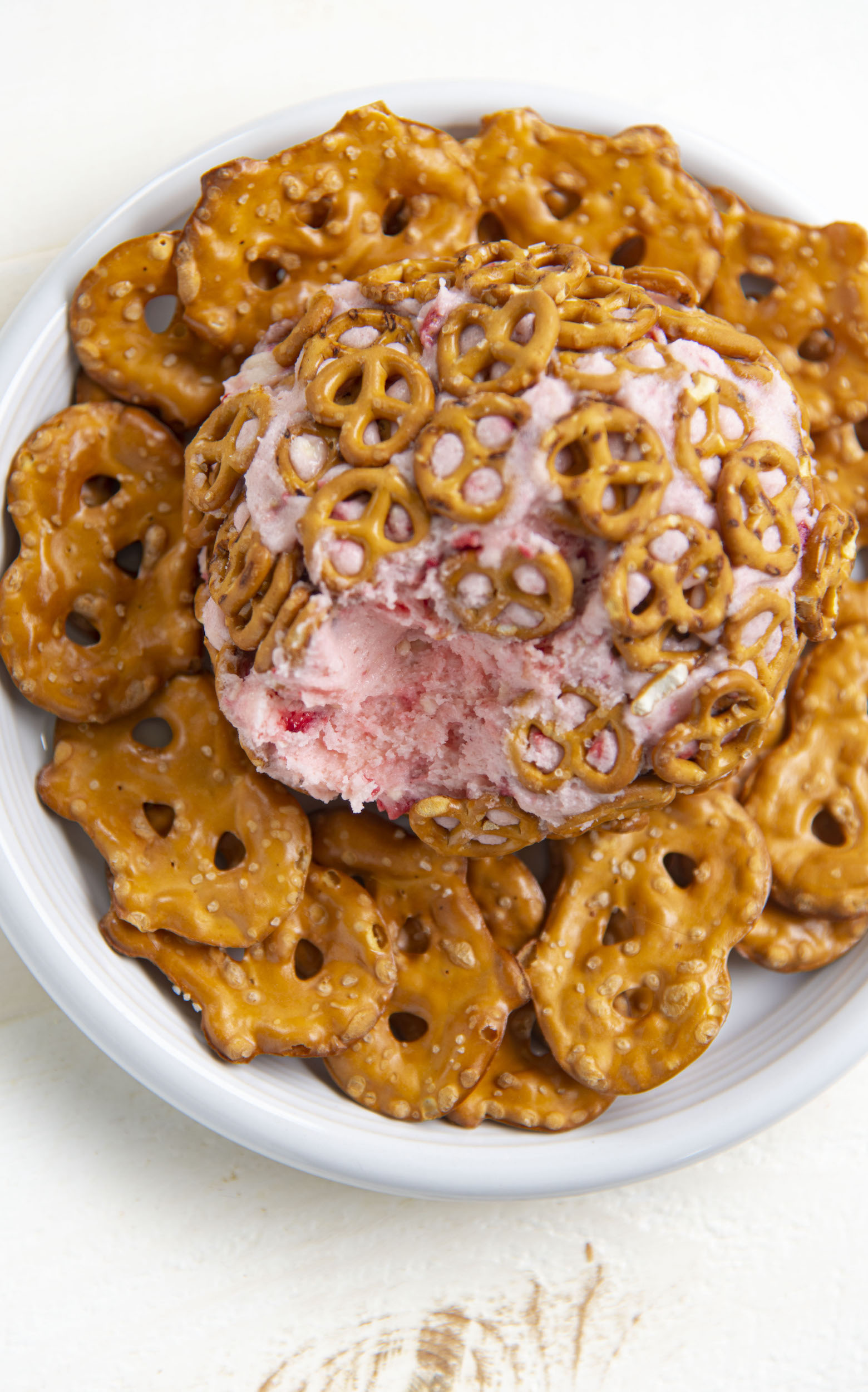 Overhead view of Strawberry Pretzel Cheesecake Cheese Ball with dip missing