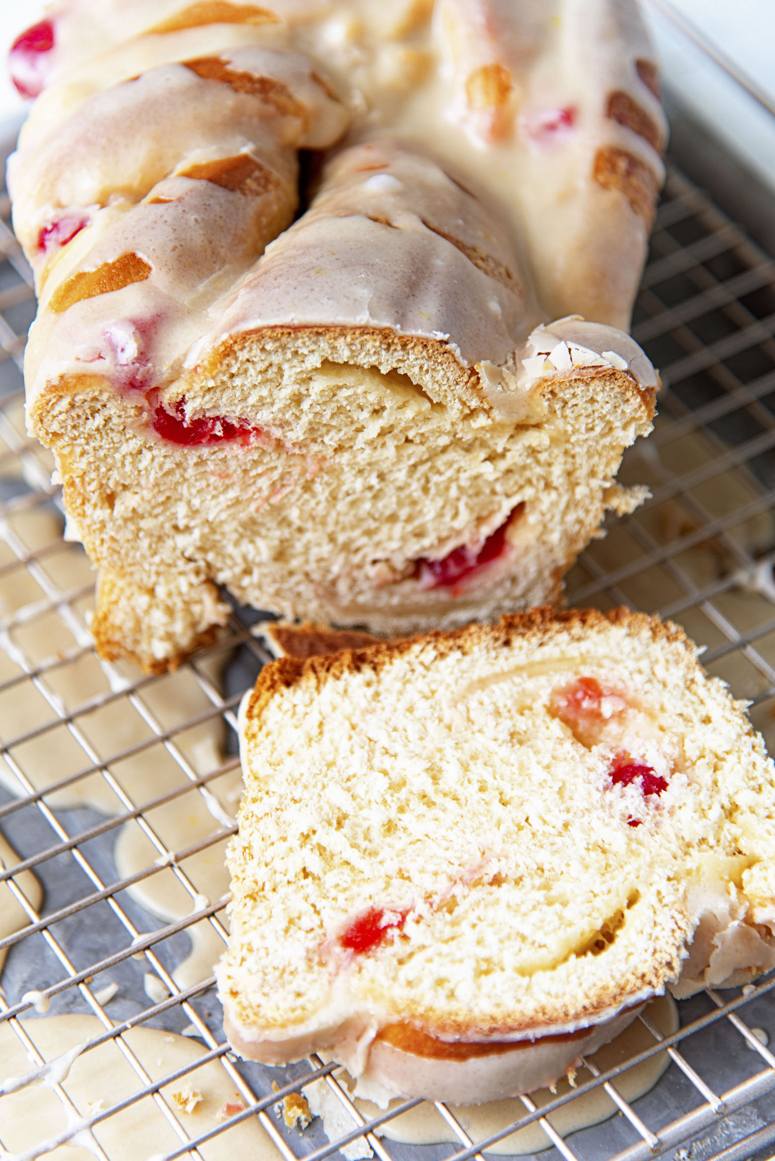 Sliced open Cherry Coke Float Babka on a wire rack with dripped icing down below.