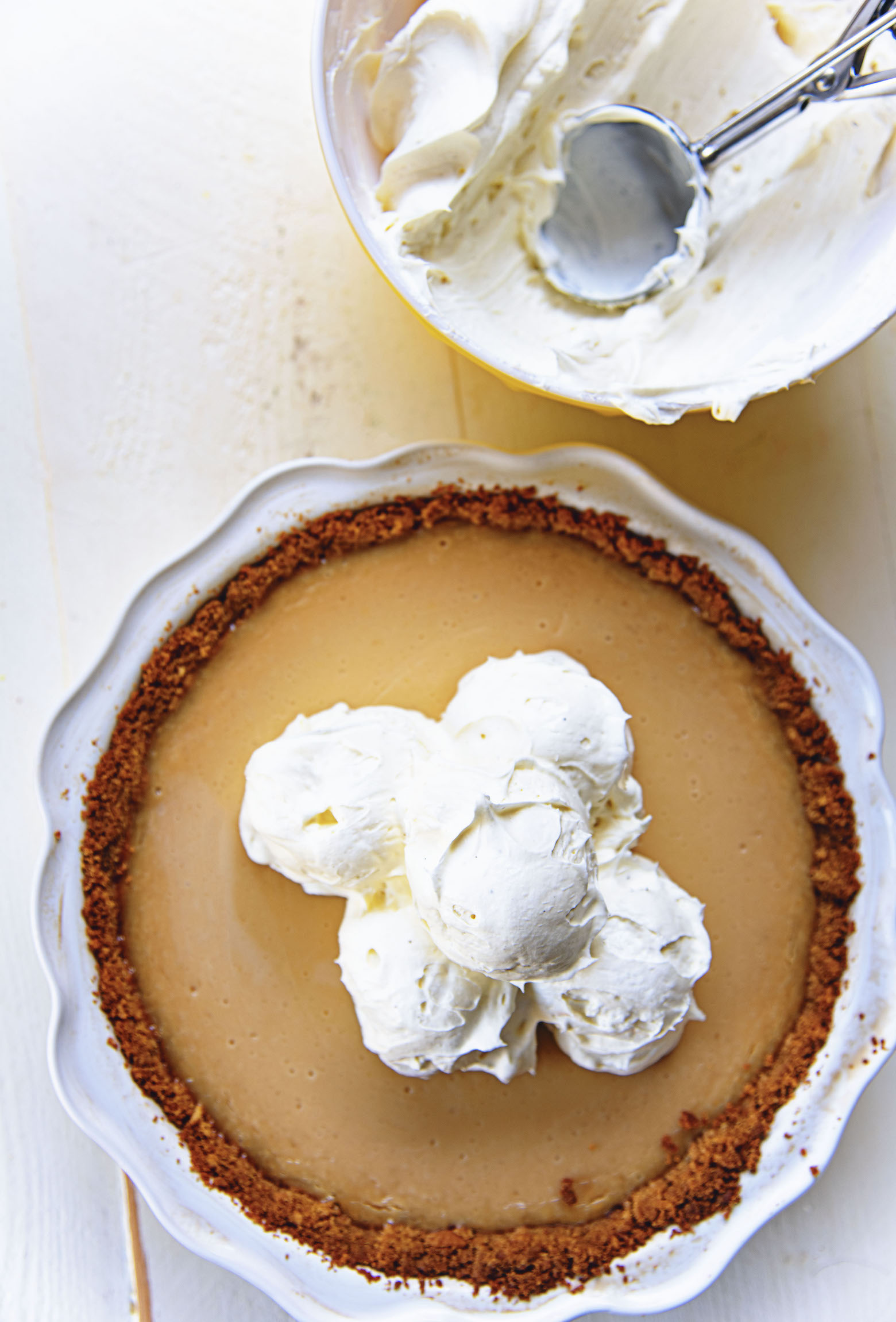 Overhead photo of the pie with a bowl of the whipped cream on the side. 