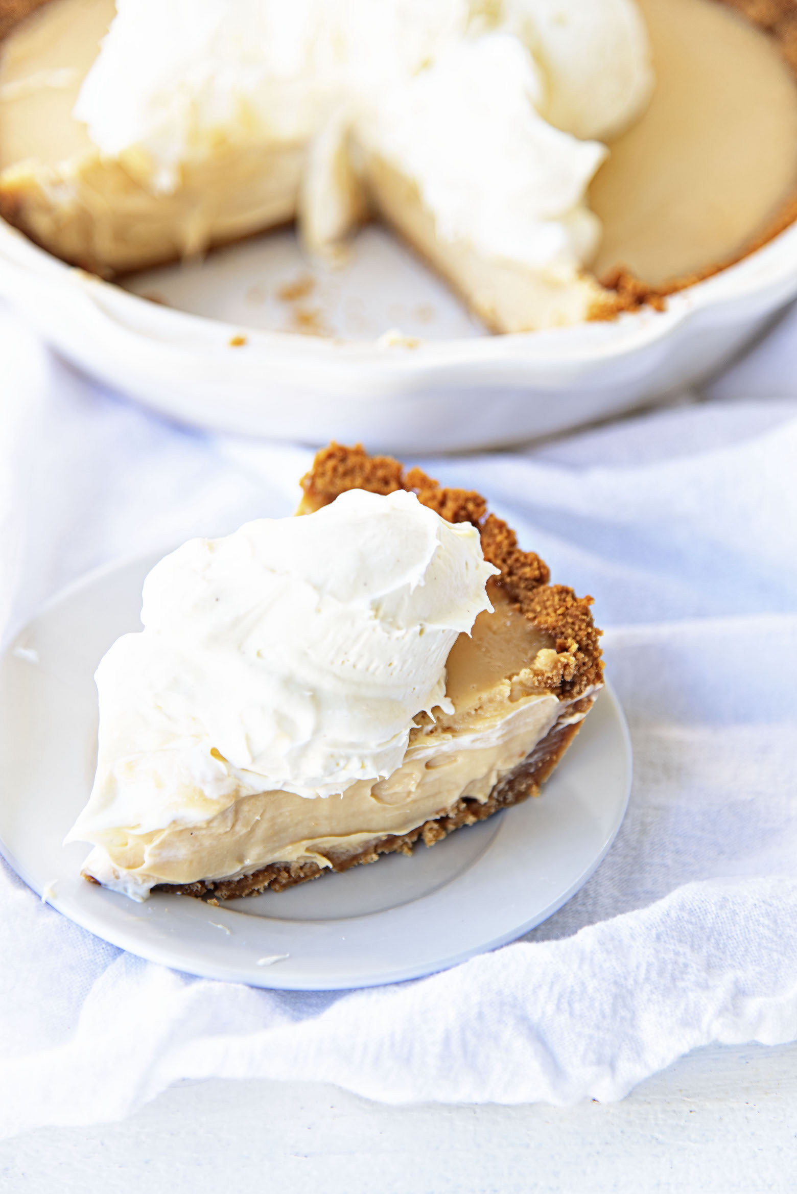 Three quarter view of sliced pie with whipped cream.