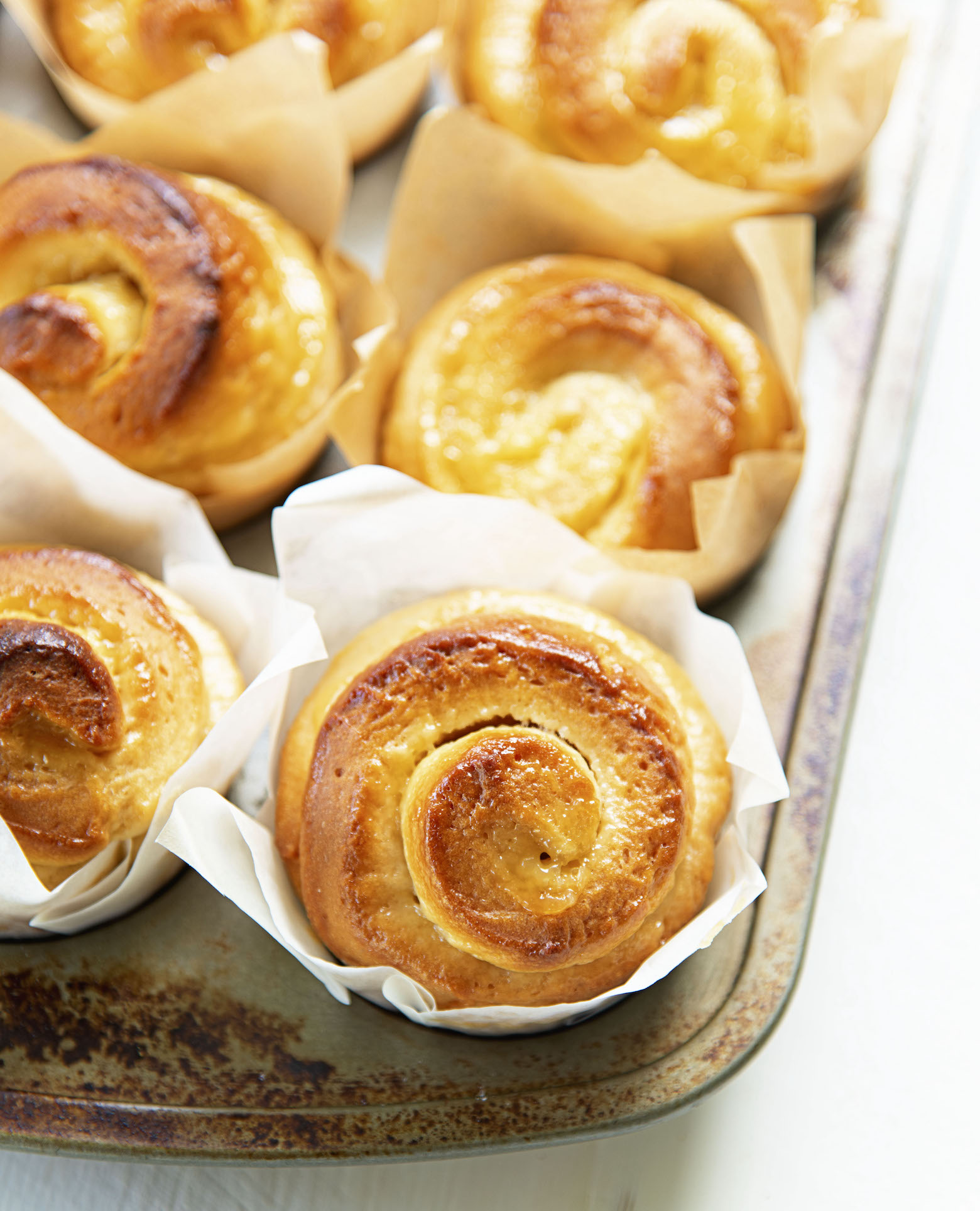 Picture of the rolls still in muffin pan showing the swirls of lemon curd. 