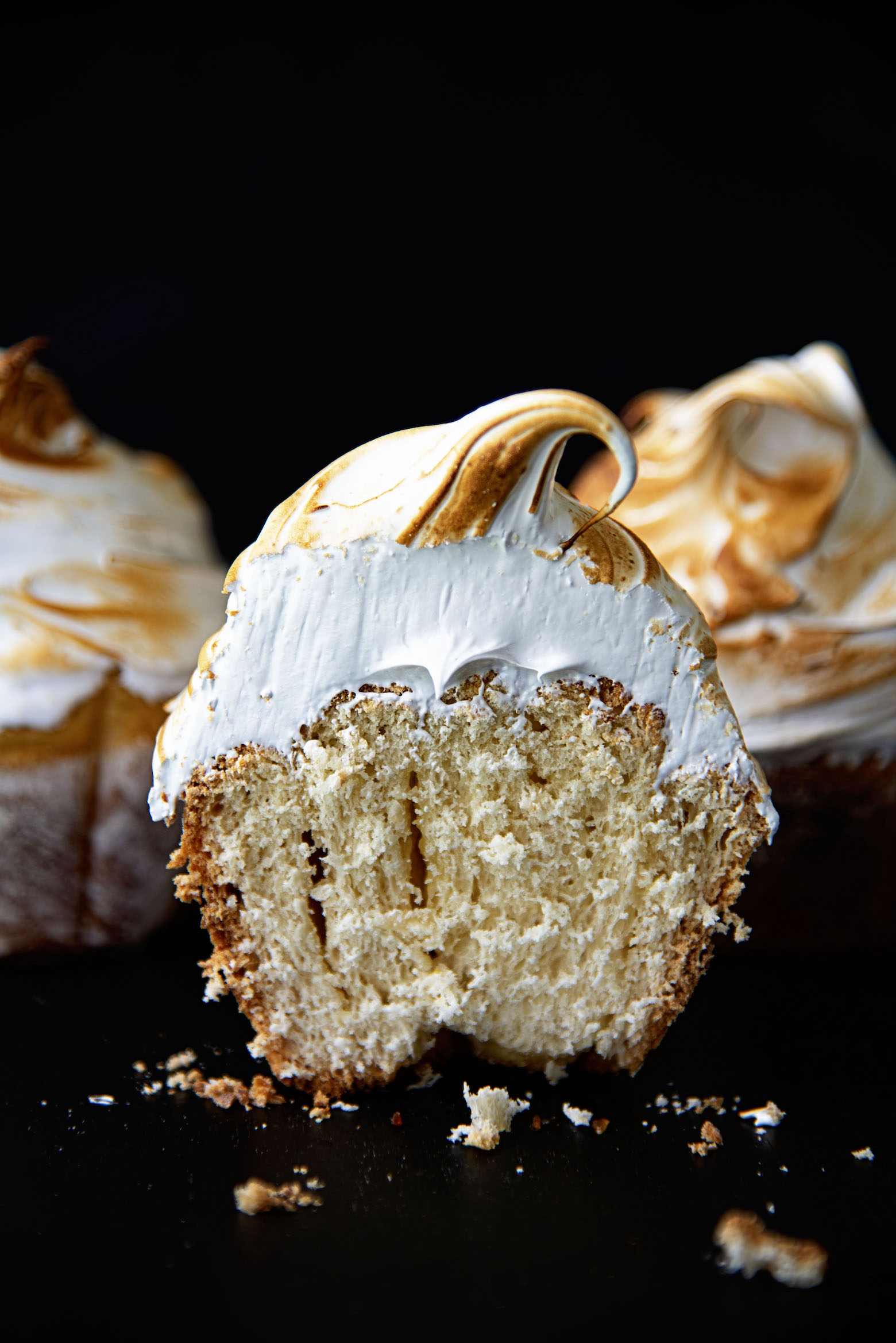 Lemon Meringue Pie Sweet Roll cut in half so you see the inside of the roll and the meringue. 