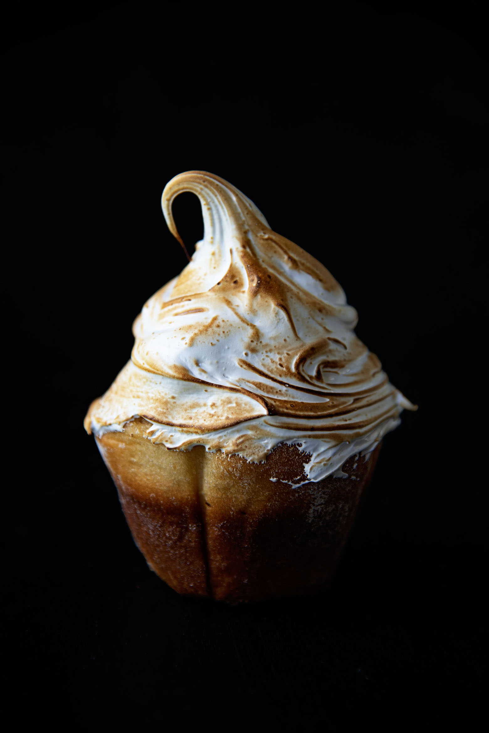 Close up photo of the sweet rolls with the toasted Swiss meringue that has a curl on top.