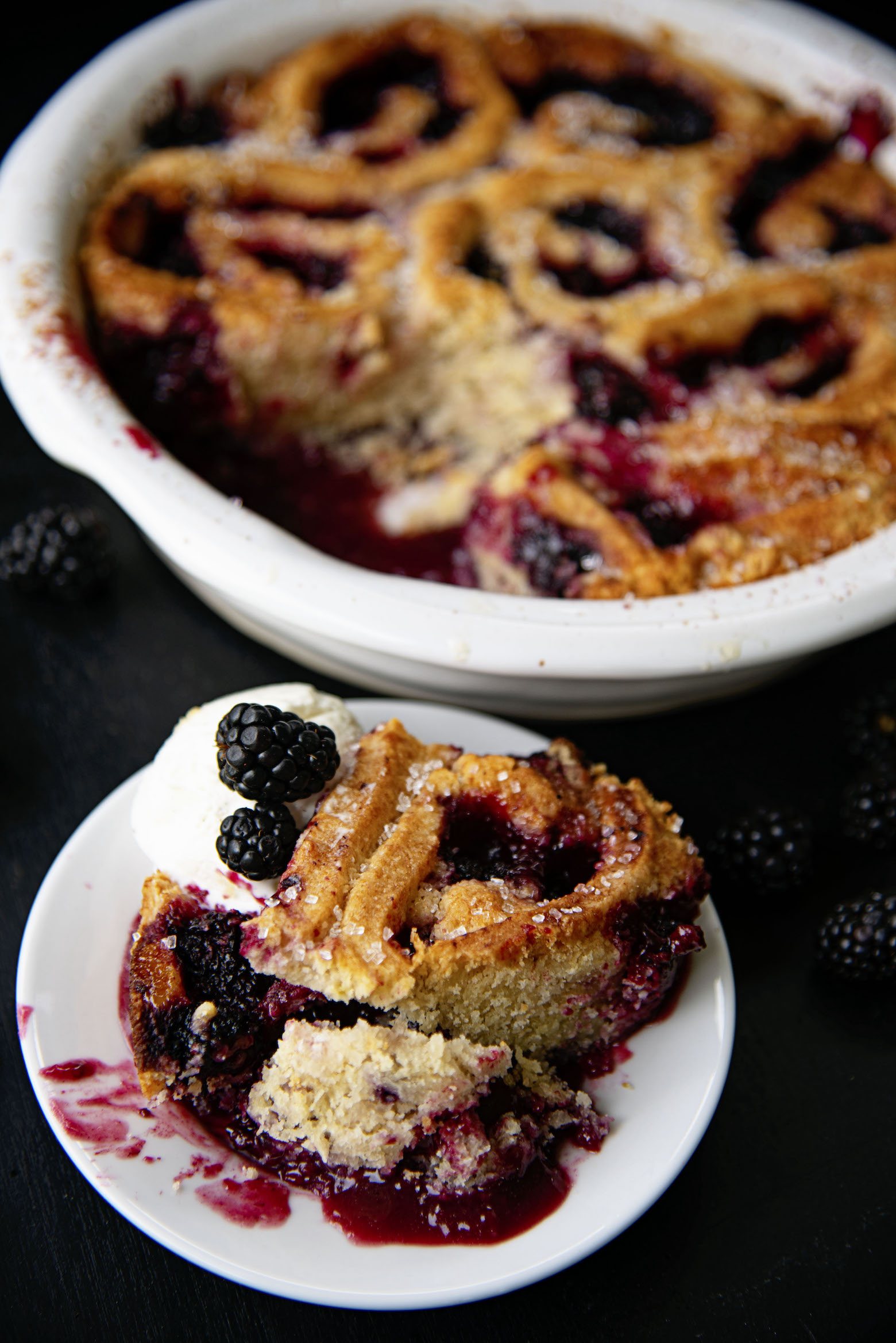 Cobbler on a plate with remaining cobbler in background.