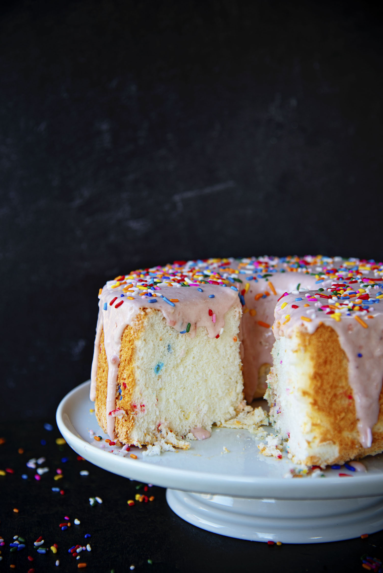 Cake Batter Angel Food Cake cut with icing dripping down.