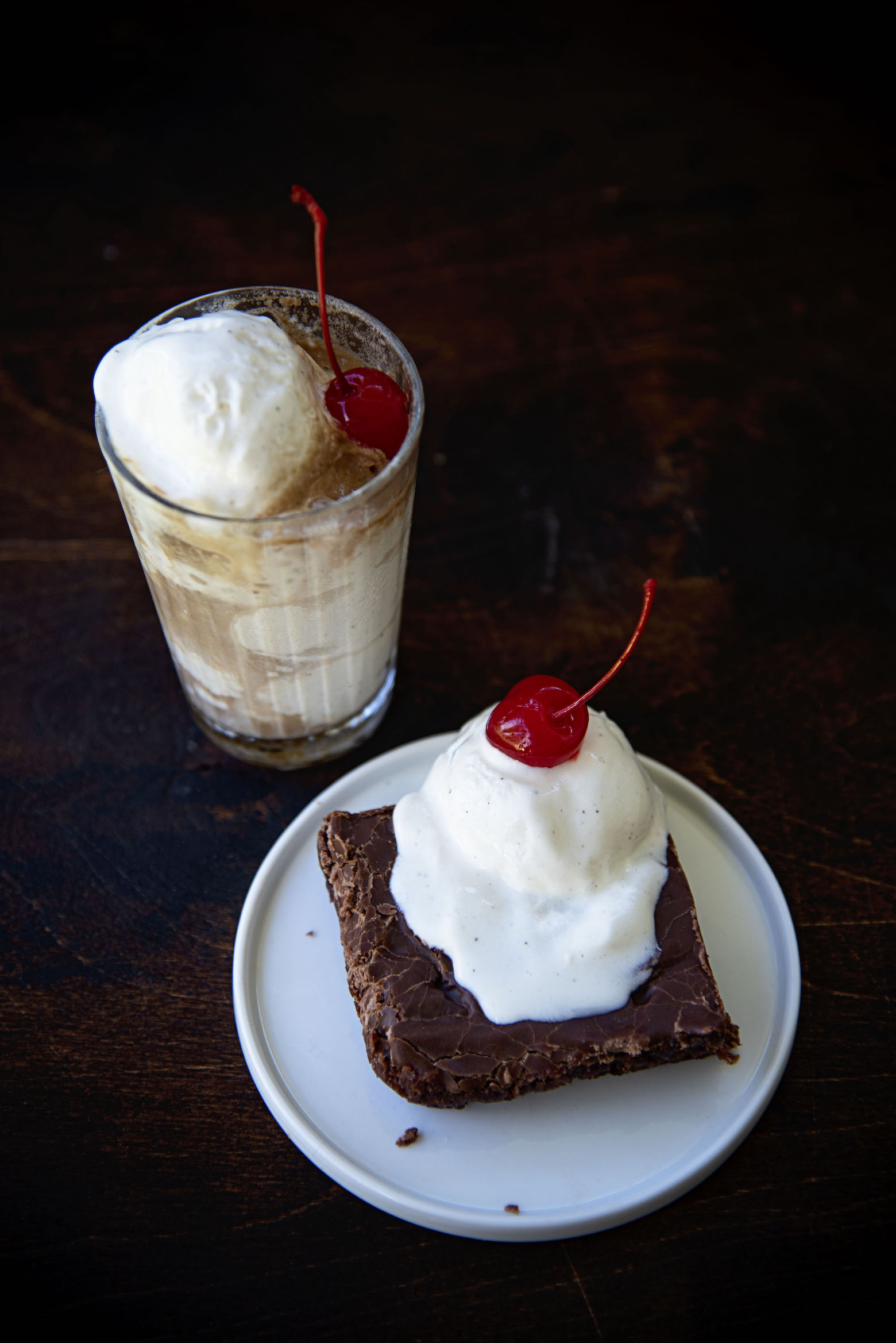 Slice of Root Beer Float Texas Sheet Cake on a plate with a root beer float on the side. 