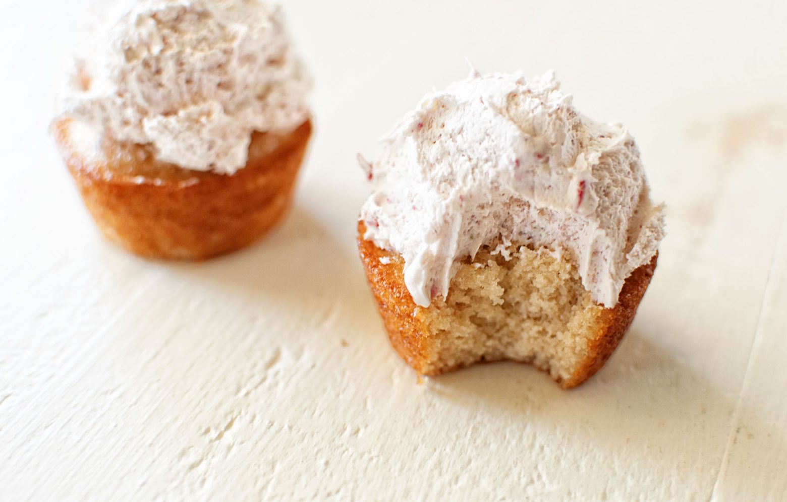 Strawberries and cream cupcakes with bite out of. 