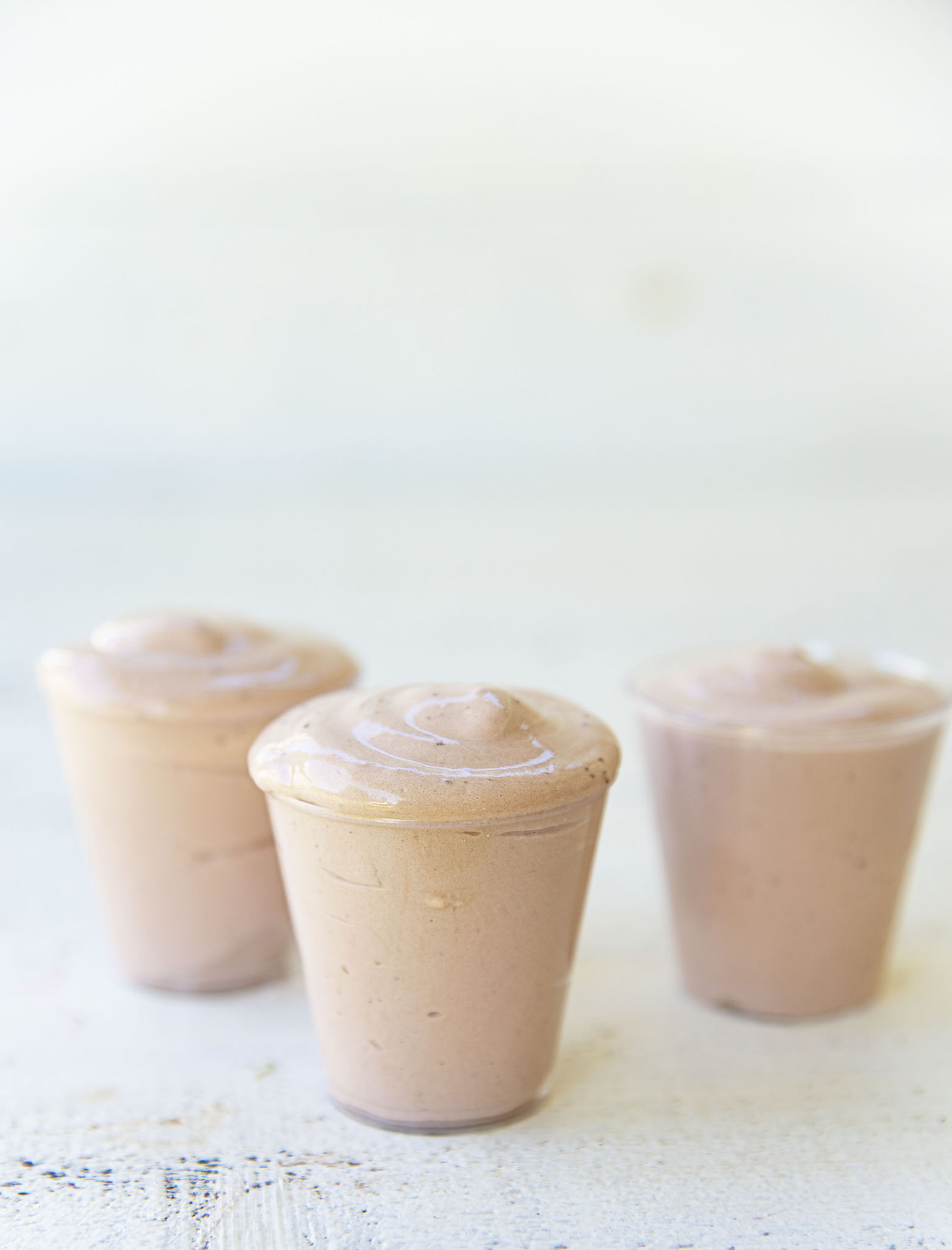 Side view of three Chocolate Frosty Pudding Shots