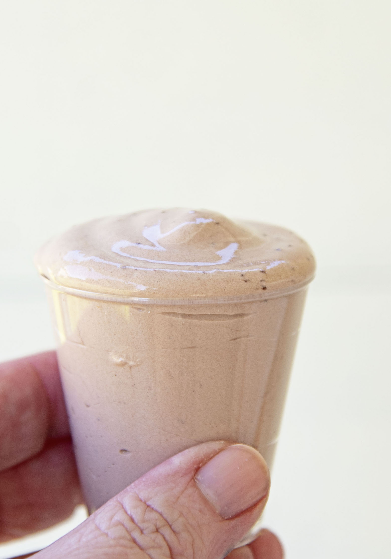  Chocolate Frosty Pudding Shot being held in fingers.
