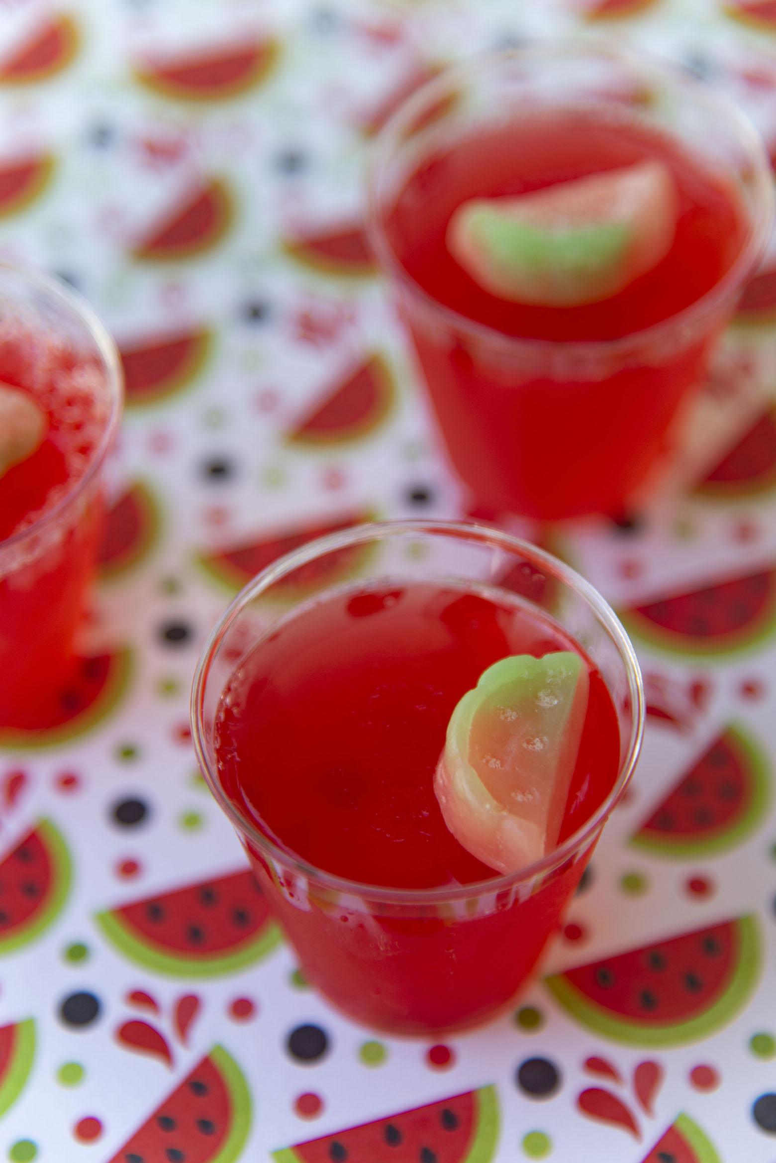 Three quarter shot of Watermelon Lemonade Jello Shots with candy watermelon on top of shot 