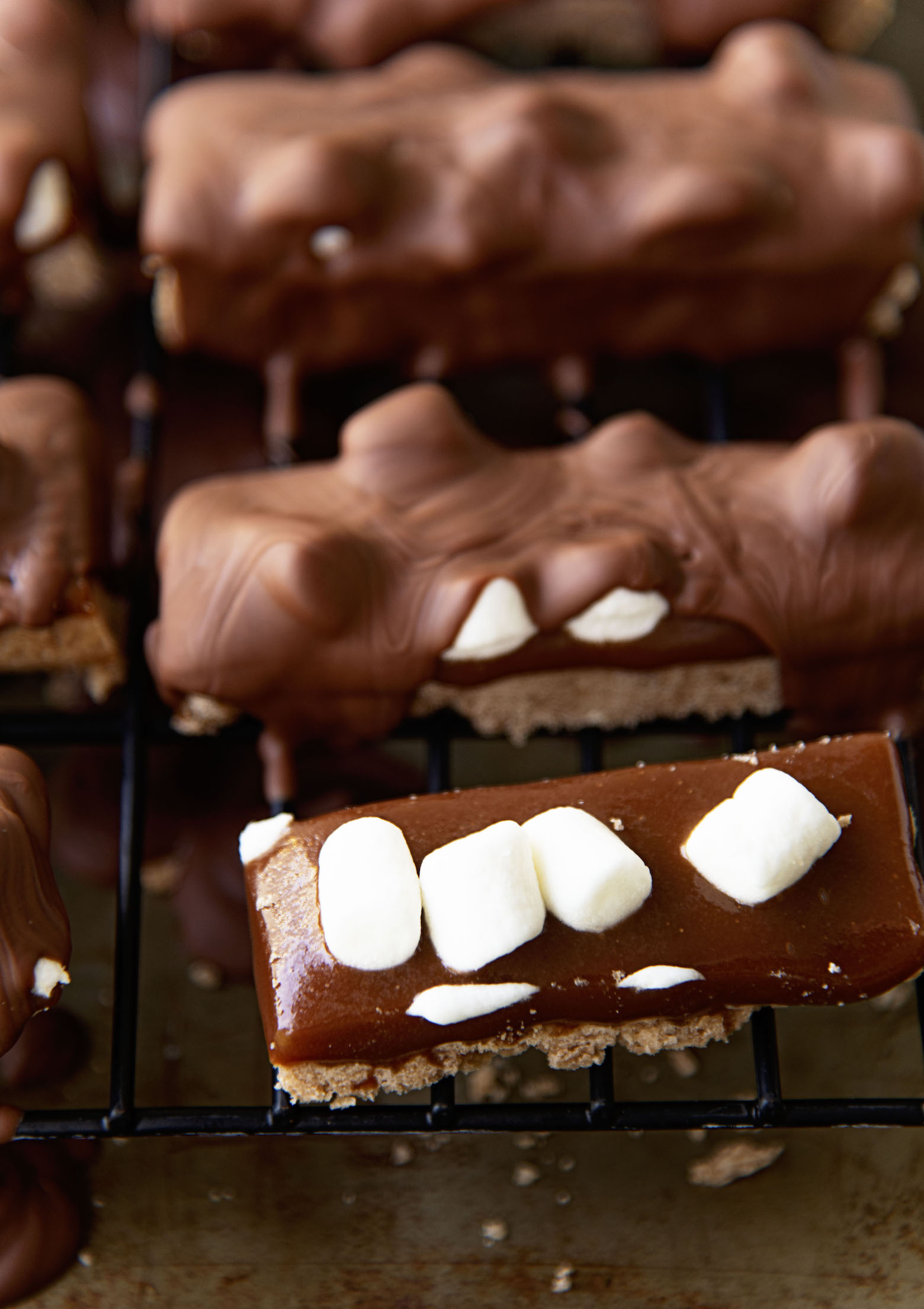 Hot Chocolate Millionaire Bars on a wire rack with one of them not finished. 