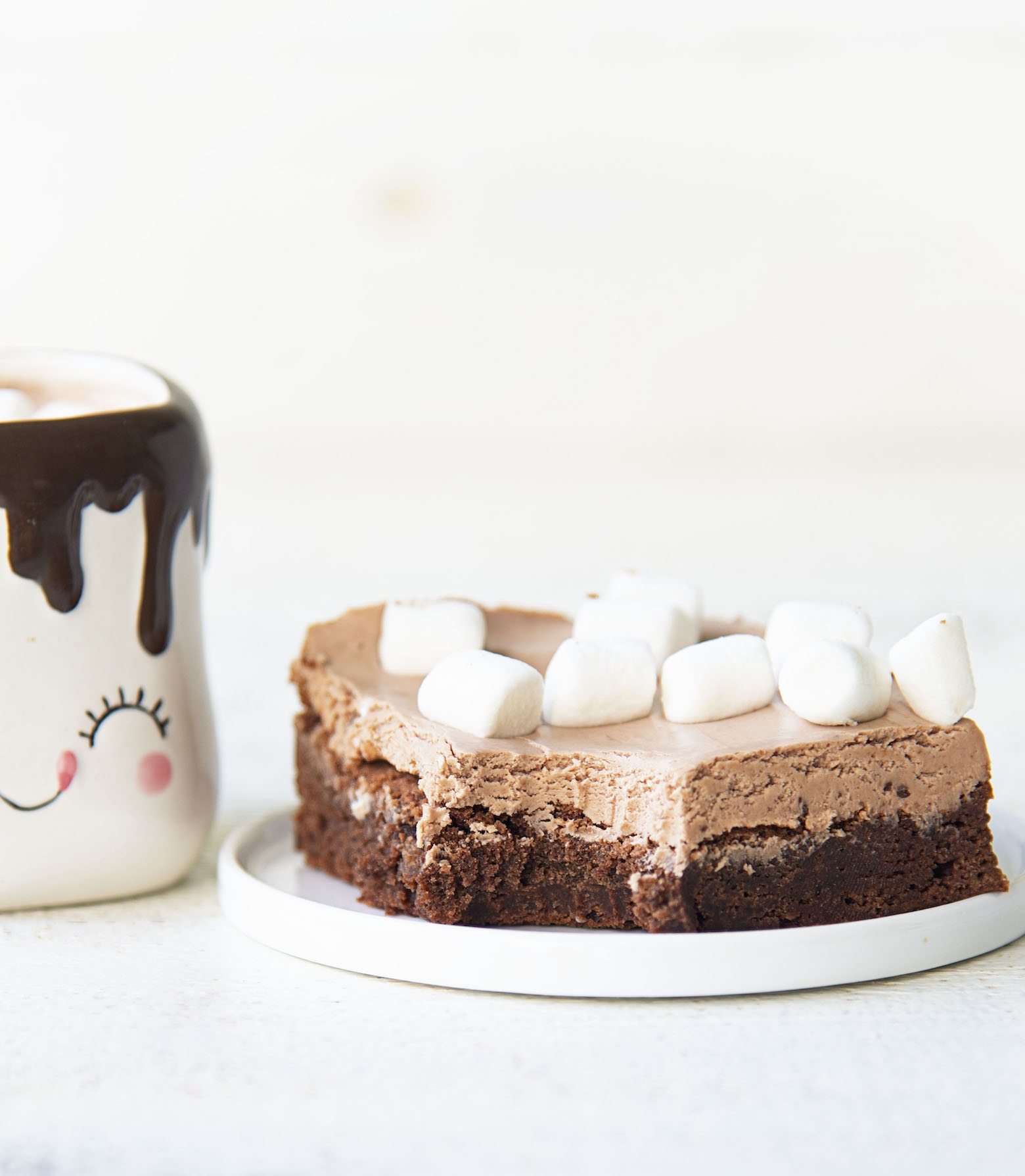 Side view of the hot chocolate nougat brownie with bit out of it on a plate.