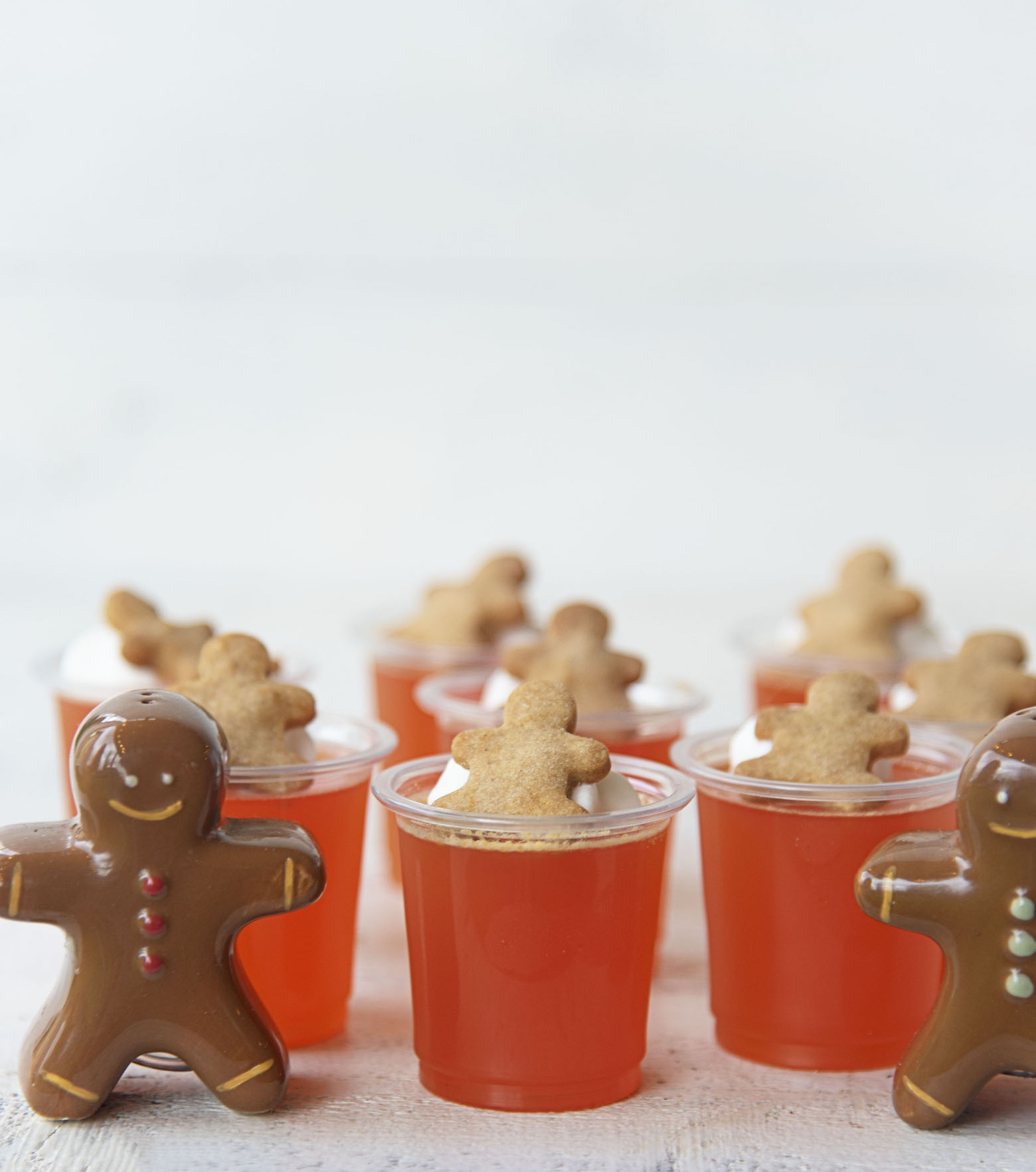 Side shot of Orange Gingerbread Jello Shots with gingerbread men figurines on each side.