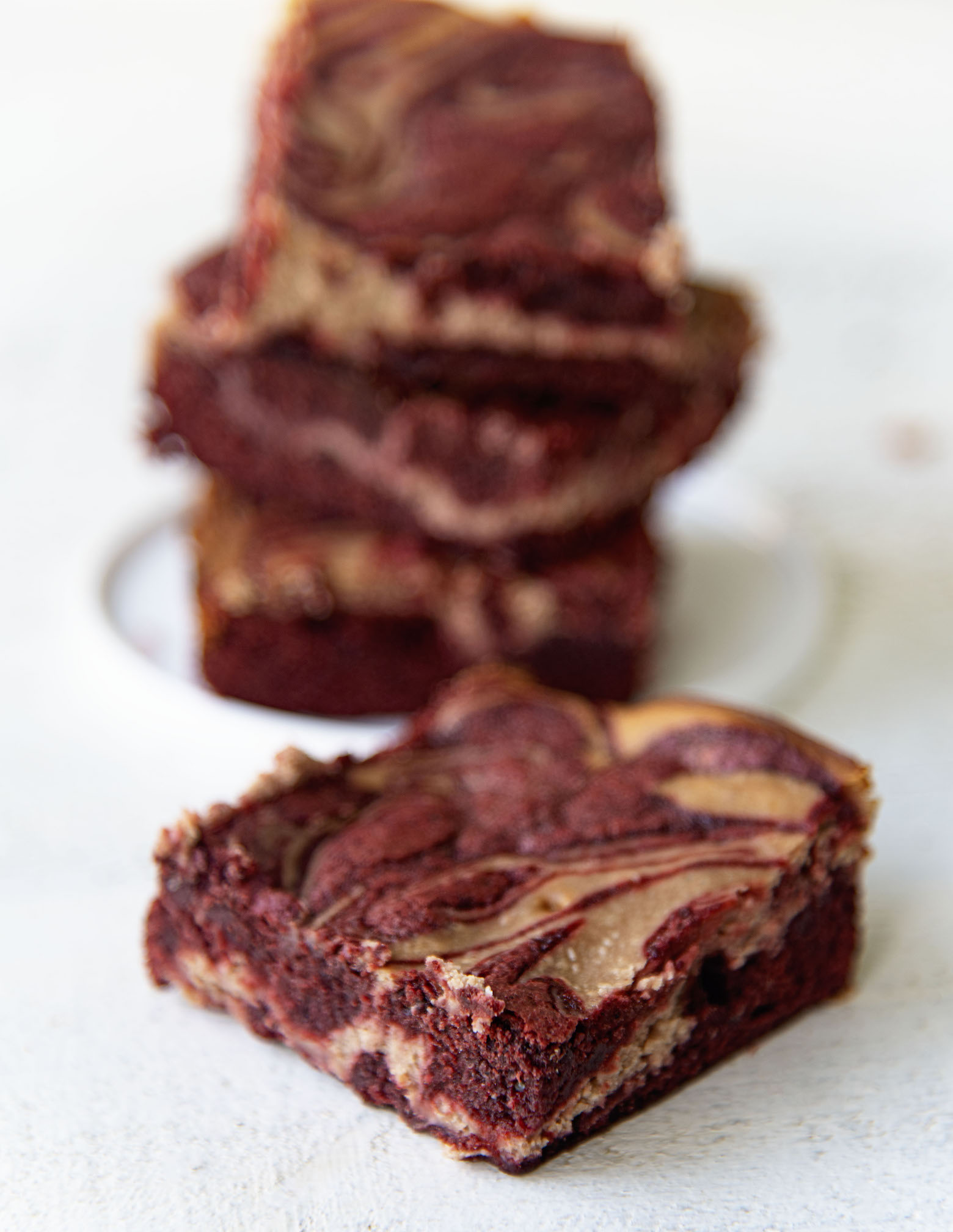 Swirled brownie in front of stack of three brownies. 