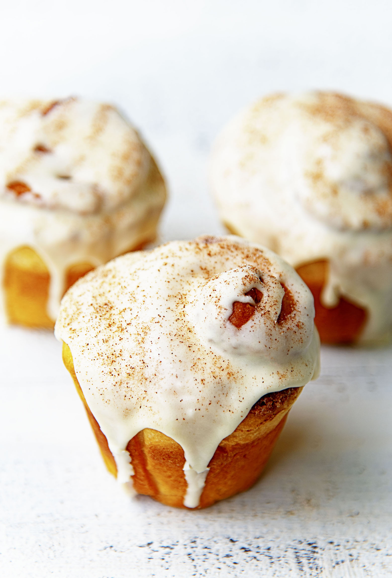 Three Bourbon Eggnog Breakfast Buns with glaze and cinnamon sugar on top. 